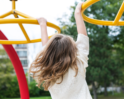 girl playing on jungle gym